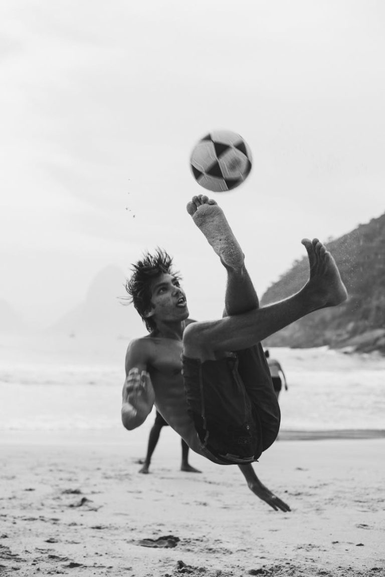 grayscale photography of man playing soccer